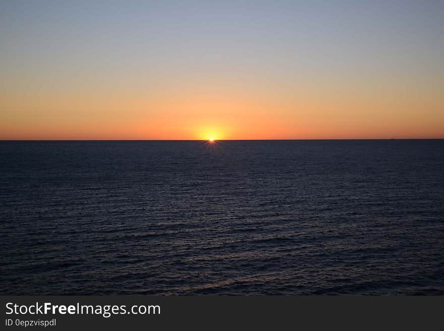 Sunset in the open sea and colored sky above the horizon. Sunset in the open sea and colored sky above the horizon.