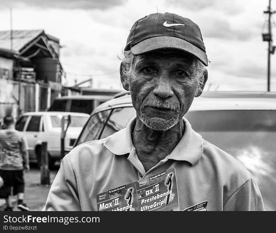 Grayscale Photography of Man Wearing Polo Shirt and Nike Cap