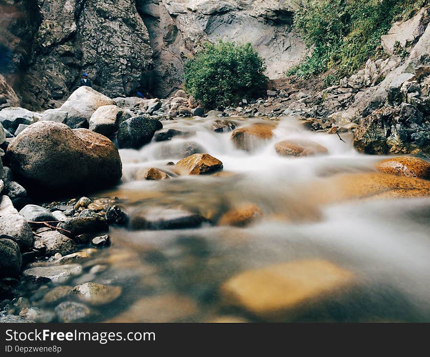 Water flowing over stones in creek with long exposure blur effect.