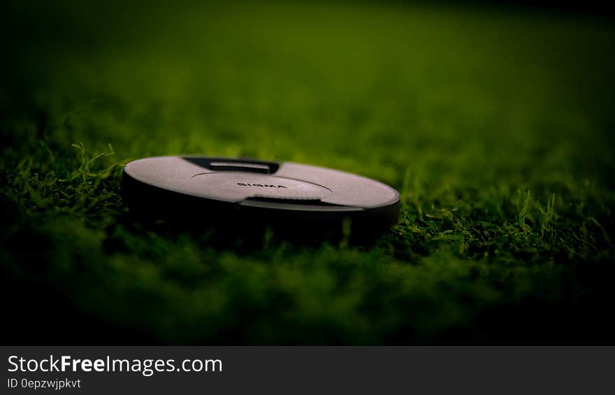 Black Camera Lens Cover on Green Grass