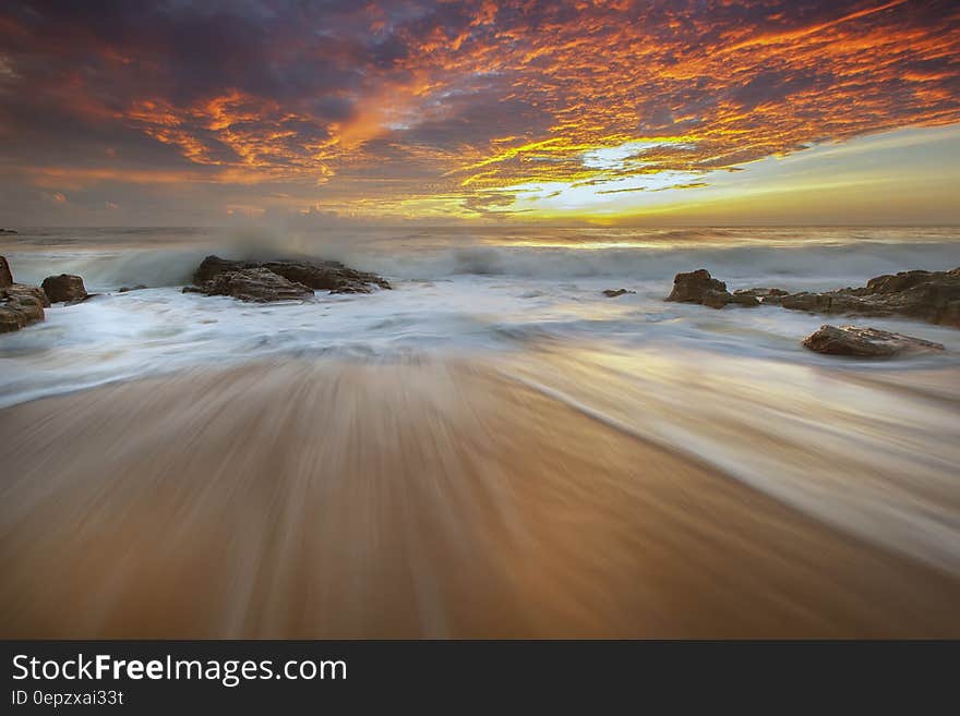 A long exposure of waves hitting the beach with sunset skies. A long exposure of waves hitting the beach with sunset skies.