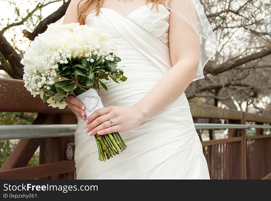 A bride dressed in white gown with a white bouquet. A bride dressed in white gown with a white bouquet.