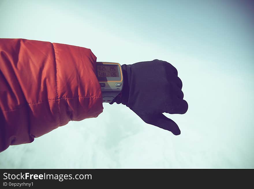 Person in Red Jacket and Black Gloves Wearing Gray Digital Watch