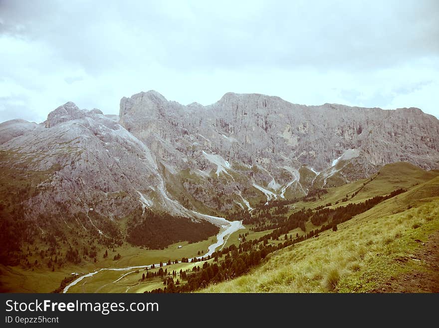 Grey Formation of Rock Mountain by the Green Field during Daytime