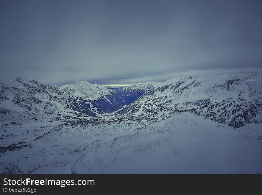 Mountain Covered in Snow Under White Cloudy Sky during Daytime