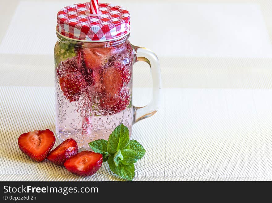 Strawberry Fruits Sliced in Half Near Clear Glass Container