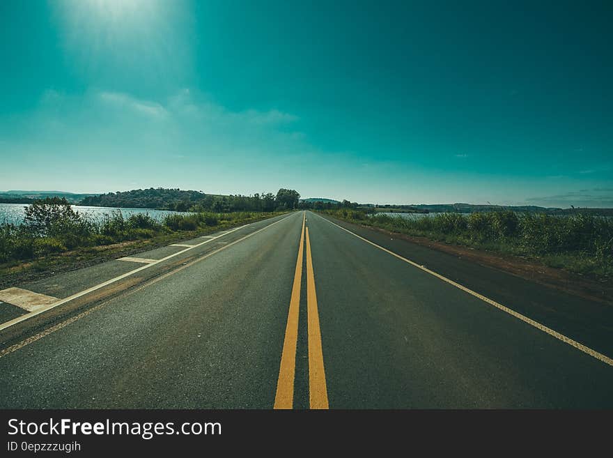 Road leading along waterfront in countryside on sunny day. Road leading along waterfront in countryside on sunny day.