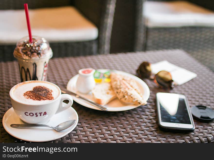 Coffee and different snacks on table with mobile. Coffee and different snacks on table with mobile.