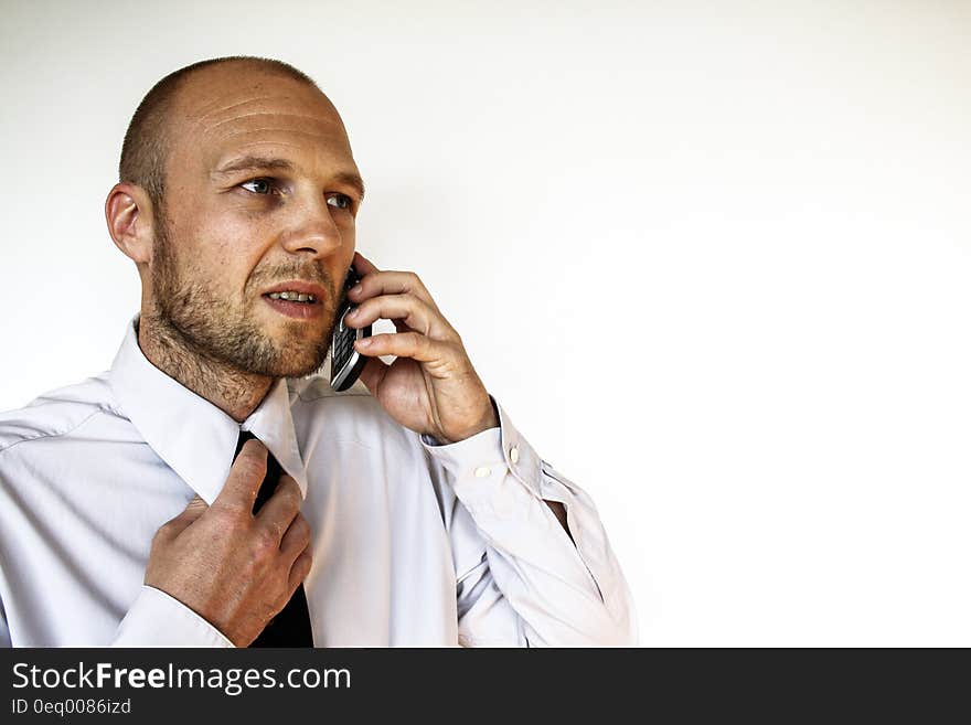 Man Wearing White Dress Shirt Holding Smartphone