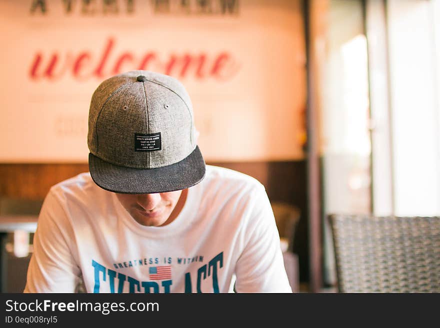 Man in White Crew Neck T Shirt Sitting