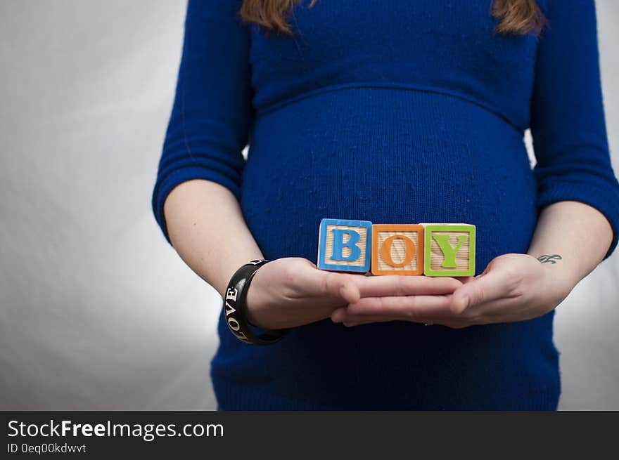 Lady Wearing Lbue Long Sleeve Dress and Holding Boy Piece Box