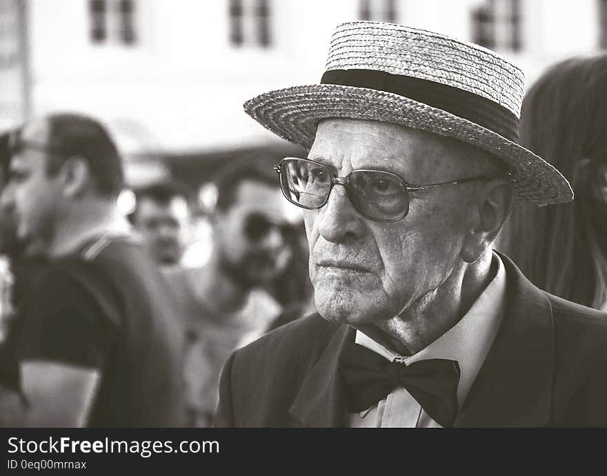 Man in Straw Hat Wearing Bow Tie With People