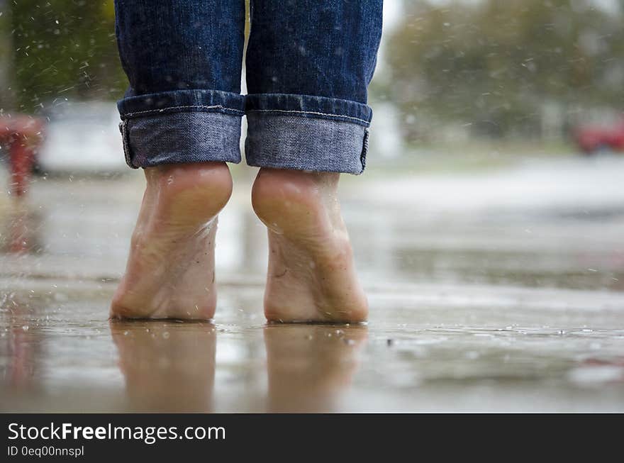 Person in Blue Denim Jeans Standing Outside the Rain