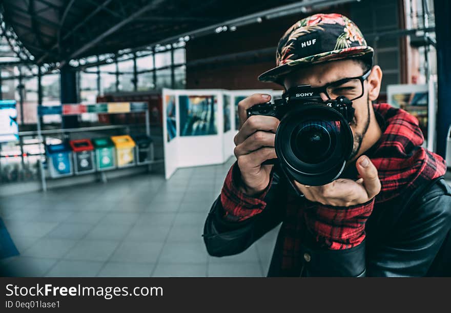 Man taking picture with professional camera inside studio. Man taking picture with professional camera inside studio.