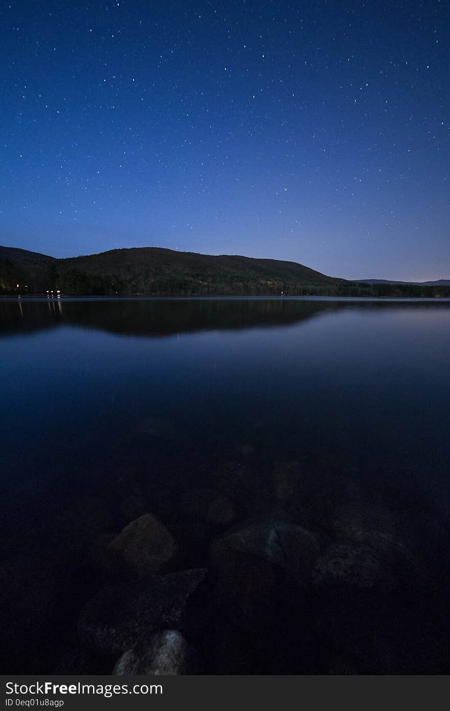 Lake View Under Clear Blue Night Sky during Night Time