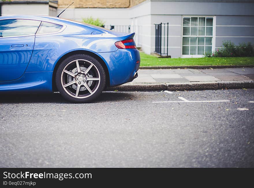 Blue Car Parked Near Grey and White Painted House