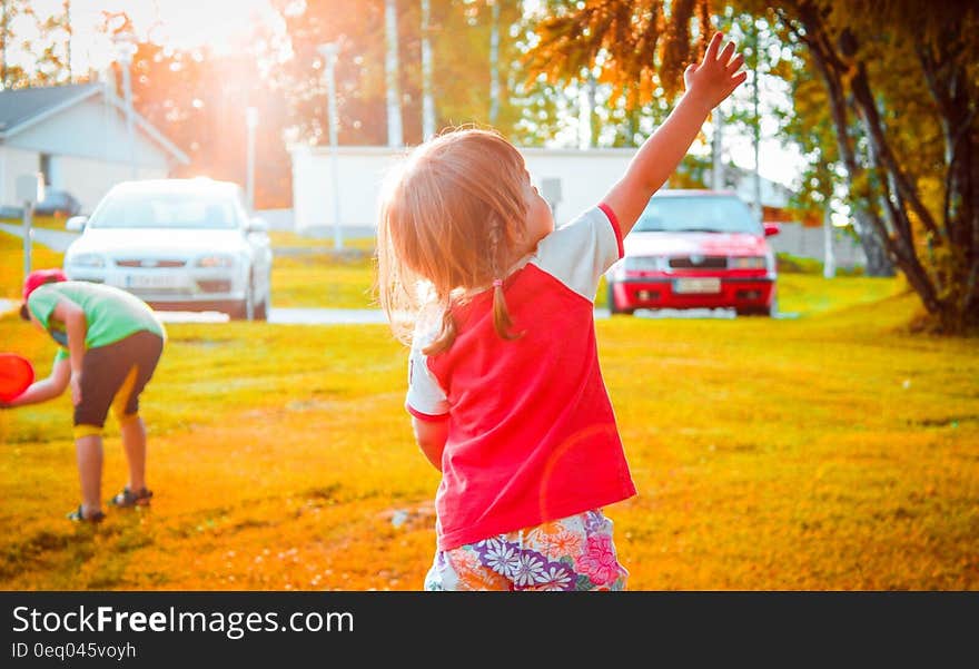 Portrait of girl playing with brother in sunny backyard. Portrait of girl playing with brother in sunny backyard.