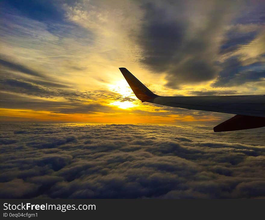 White Airplane Flying on Blue and Grey Sky