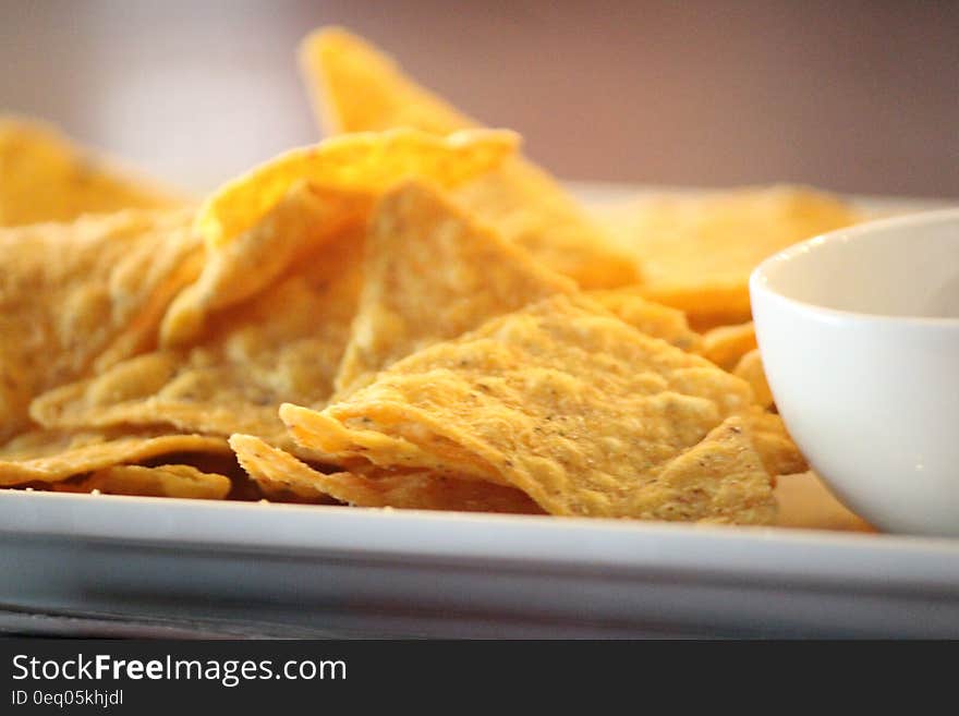 Close up of tortilla chips on white china plate with bowl. Close up of tortilla chips on white china plate with bowl.