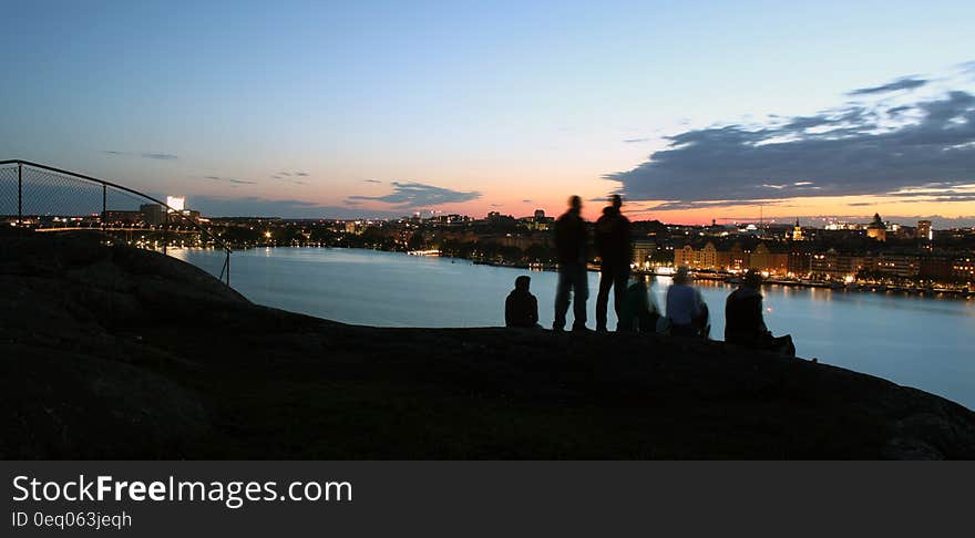 Friends on urban waterfront at sunset. Friends on urban waterfront at sunset.