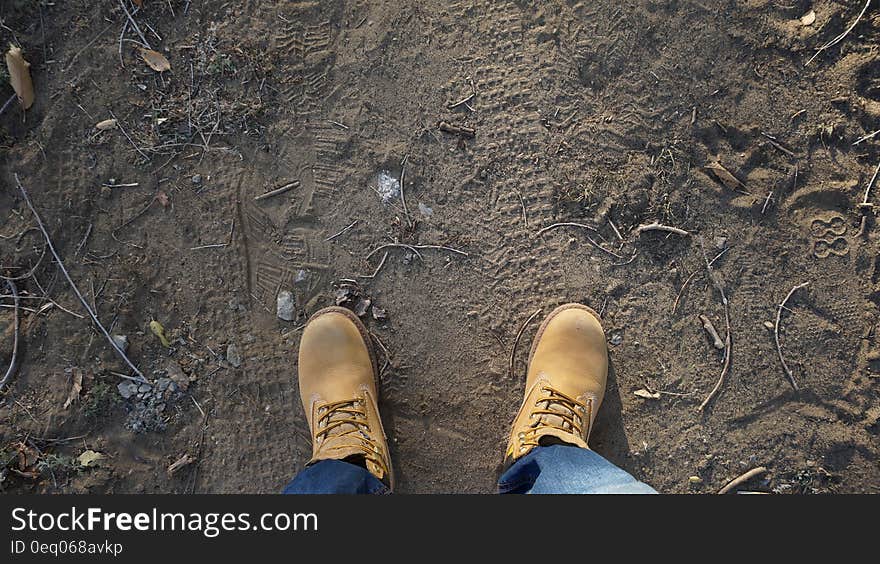 Overhead view of leather hiking boots on dirt ground. Overhead view of leather hiking boots on dirt ground.