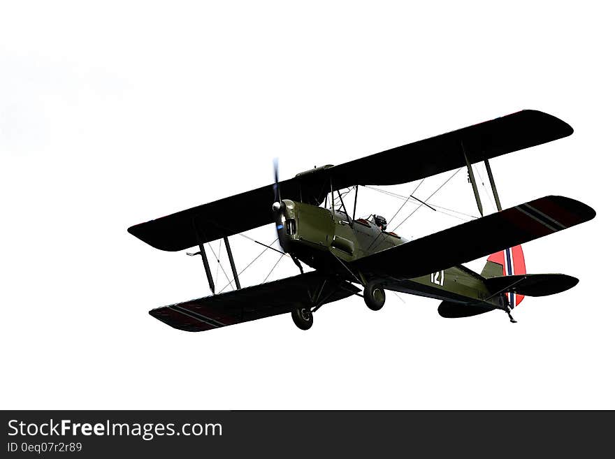 Green and Black Propeller Plane Flying Under Clear Sky