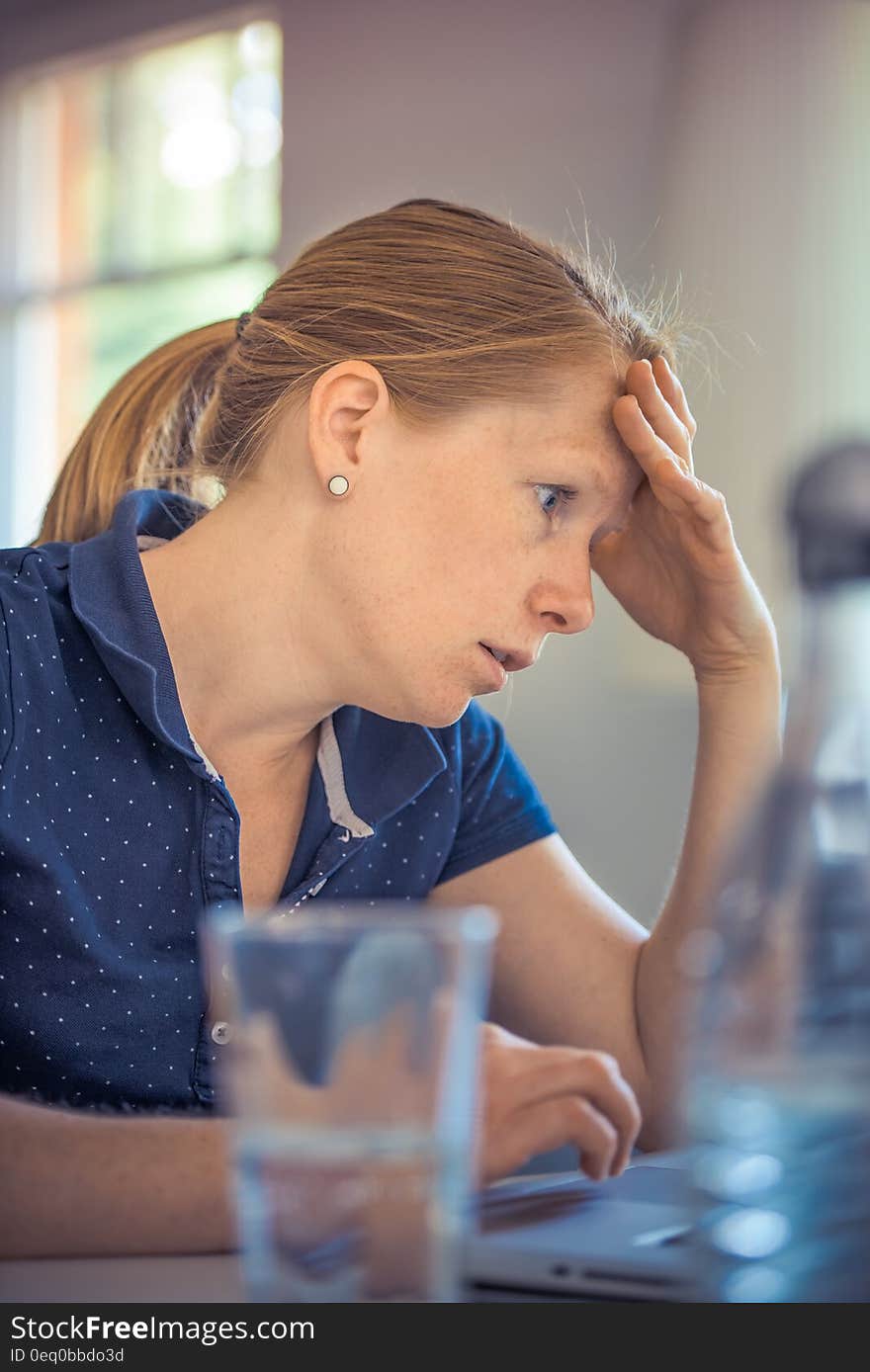 A close up of an annoyed woman sitting at a laptop. A close up of an annoyed woman sitting at a laptop.