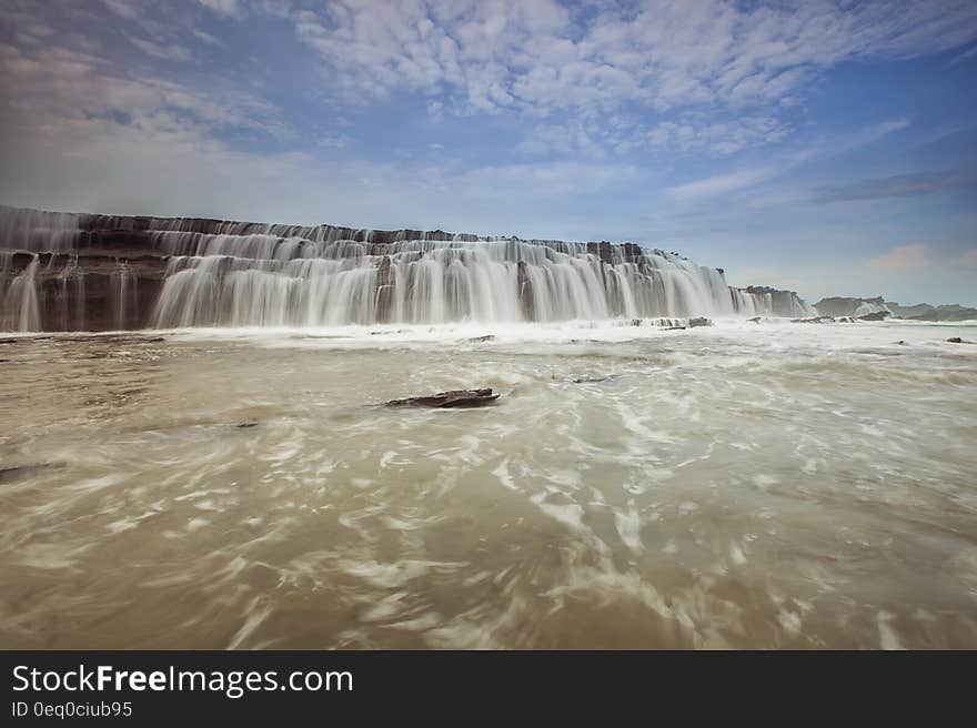 A waterfall cascading down the rocks into a pool. A waterfall cascading down the rocks into a pool.