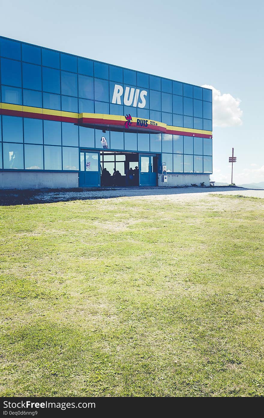 Exterior of RUIS modern glass building and green lawn on sunny day. Exterior of RUIS modern glass building and green lawn on sunny day.