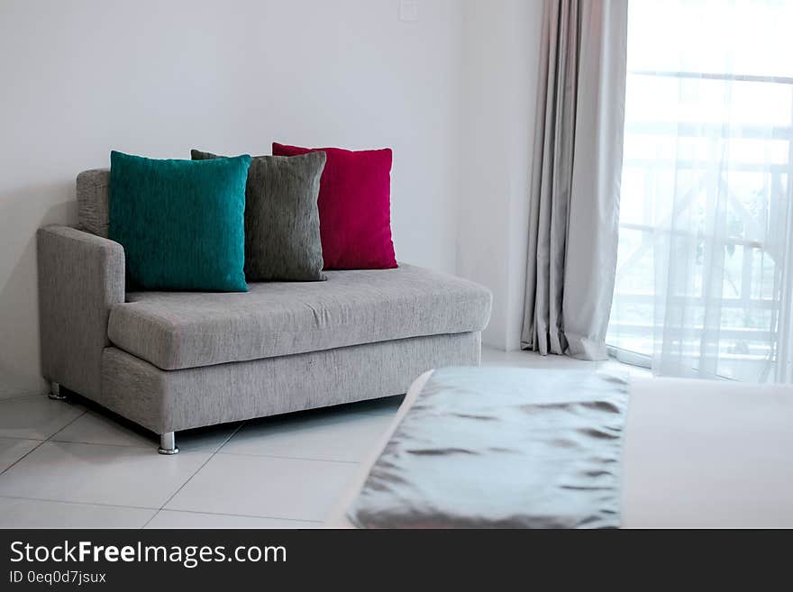 Red Throw Pillow on Gray Fabric Chaise Lounge Near Gray Window Curtain