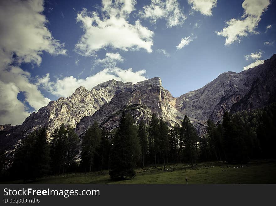 Rocky mountain peaks in landscape against blue skies on sunny day.