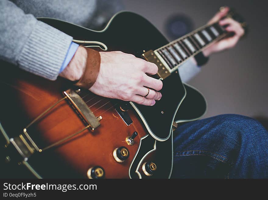 Closeup of guitar with musicians fingers strumming on strings. Closeup of guitar with musicians fingers strumming on strings.