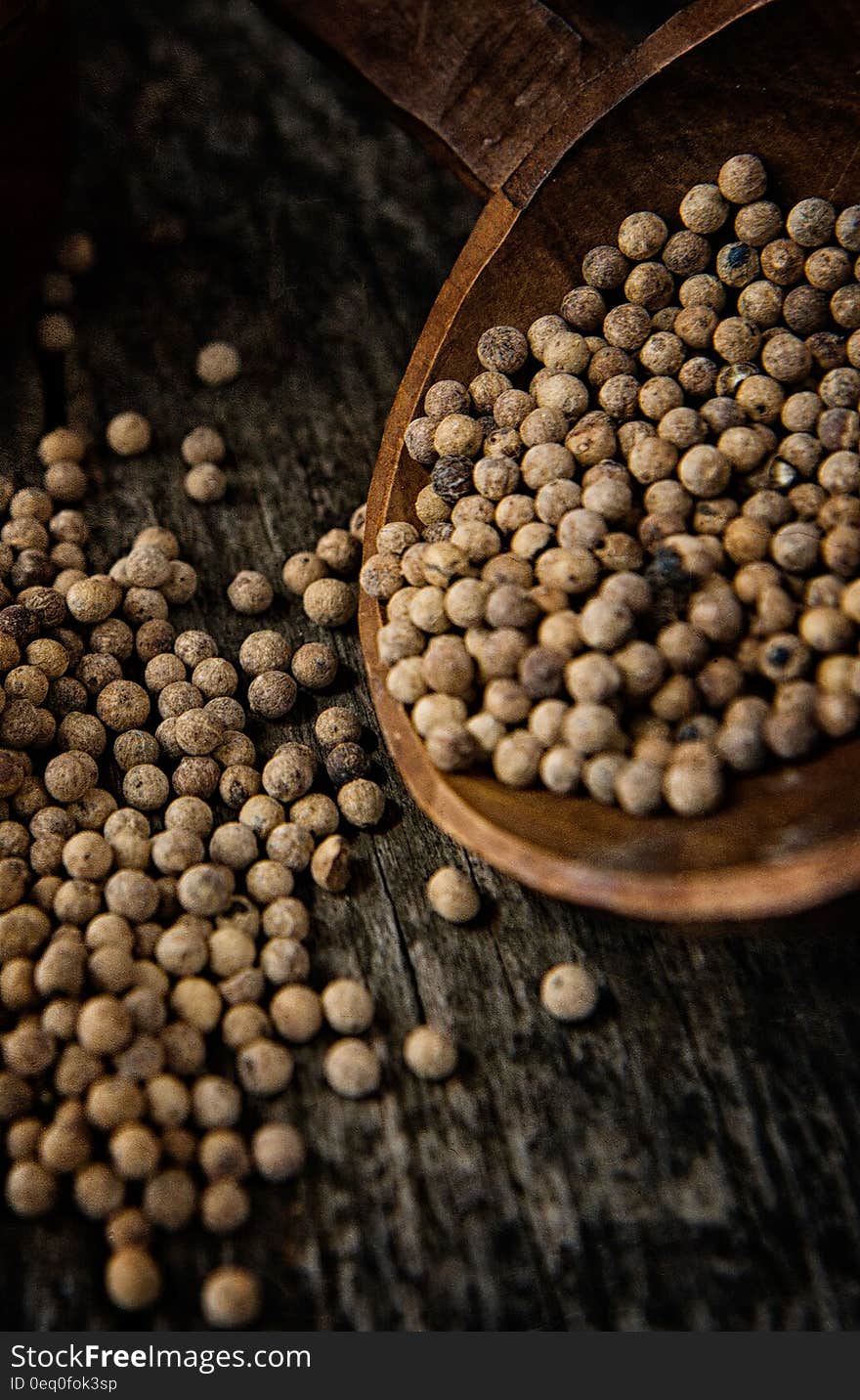 A wooden spoon with white dry peppercorns. A wooden spoon with white dry peppercorns.