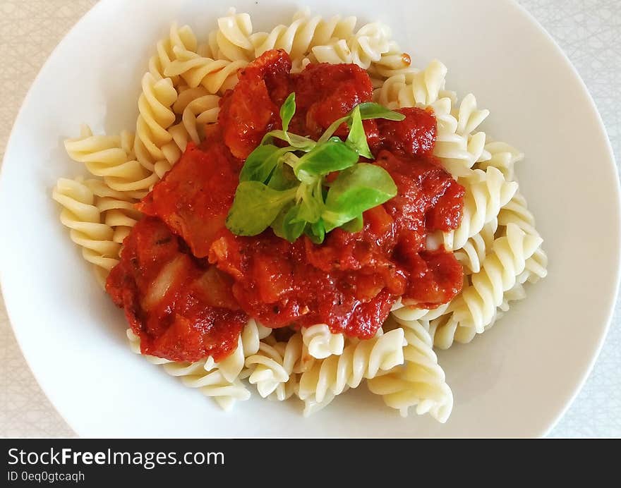 A close up of a portion of pasta with tomato sauce.