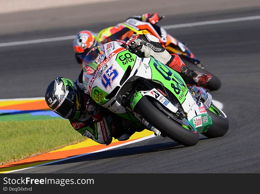 Two Motorcycle Racers Turning at Corner