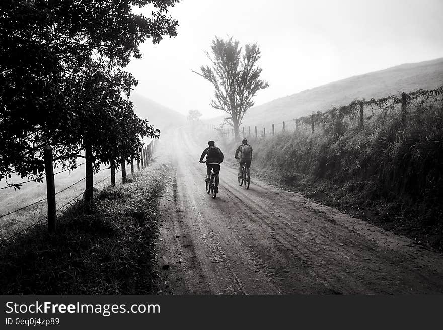 Grayscale Photography of Two Person Biking