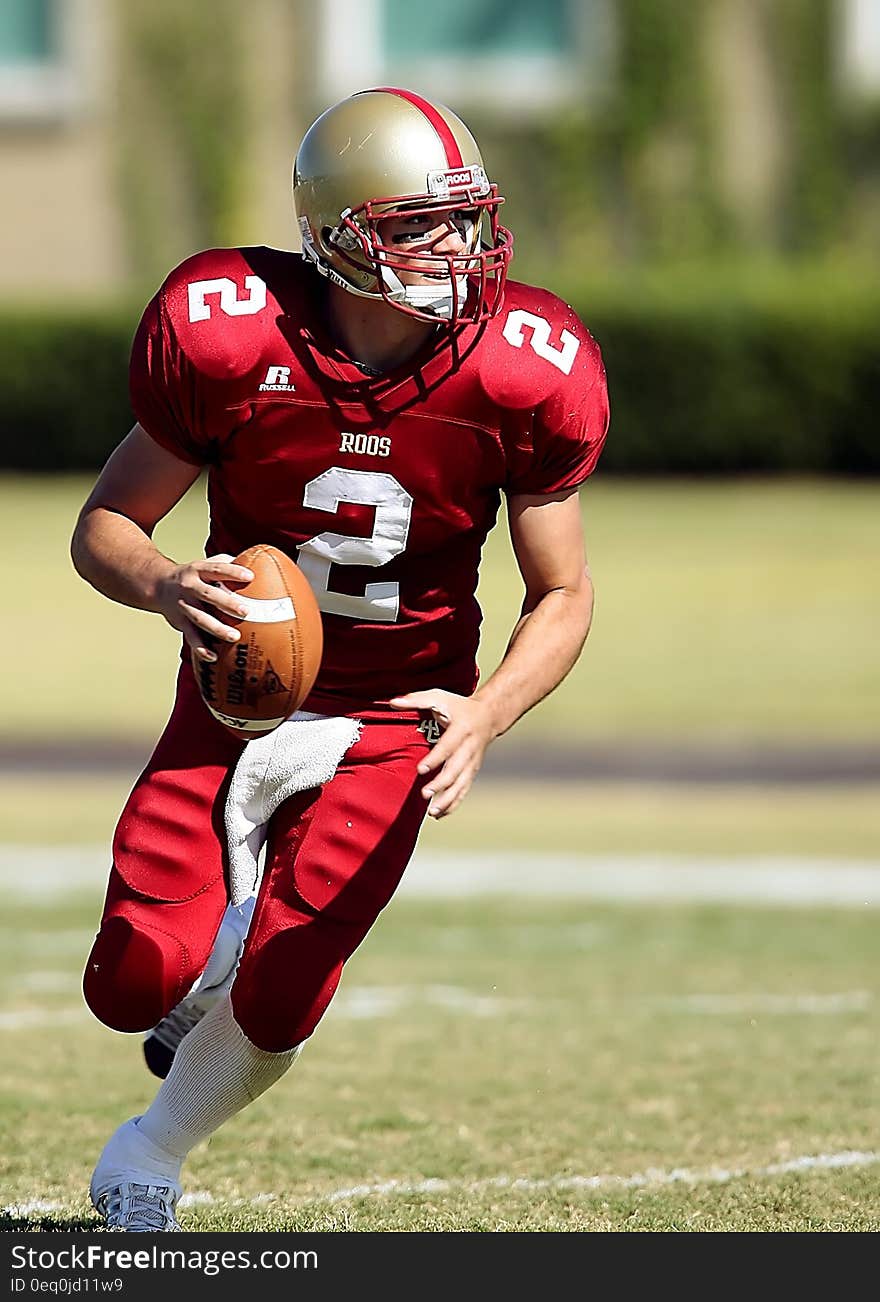 Football Player With Ball Running on Green Field during Daytime