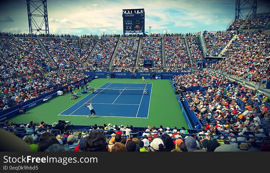 People Sitting on Bench Watching Tennis Event on Field during Daytime