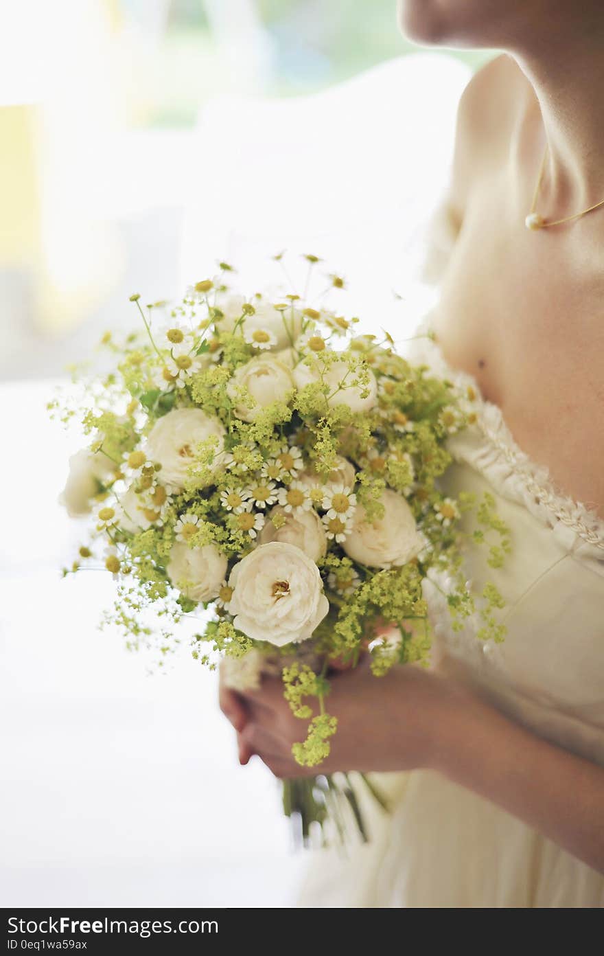 Woman in Bridal Gown Holding Bouquet of White Flowers