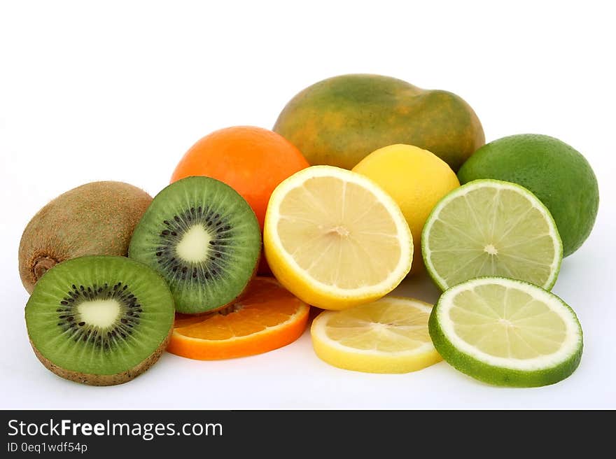 Fresh fruits, kiwis, lemons, limes and oranges on white background.