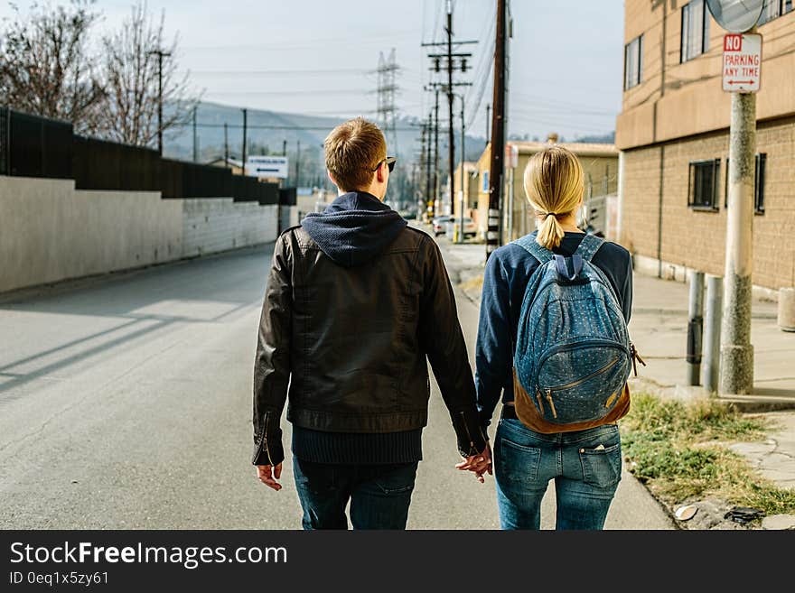 Man and Woman Holding Hands While Walking