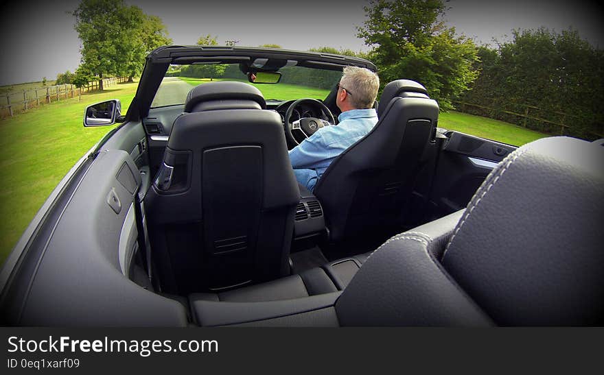 Man in Blue Dress Shirt Driving Convertible Car during Daytime