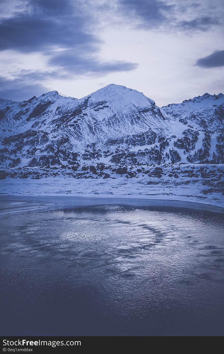 Snow Coated Mountain Under Cloudy Sky