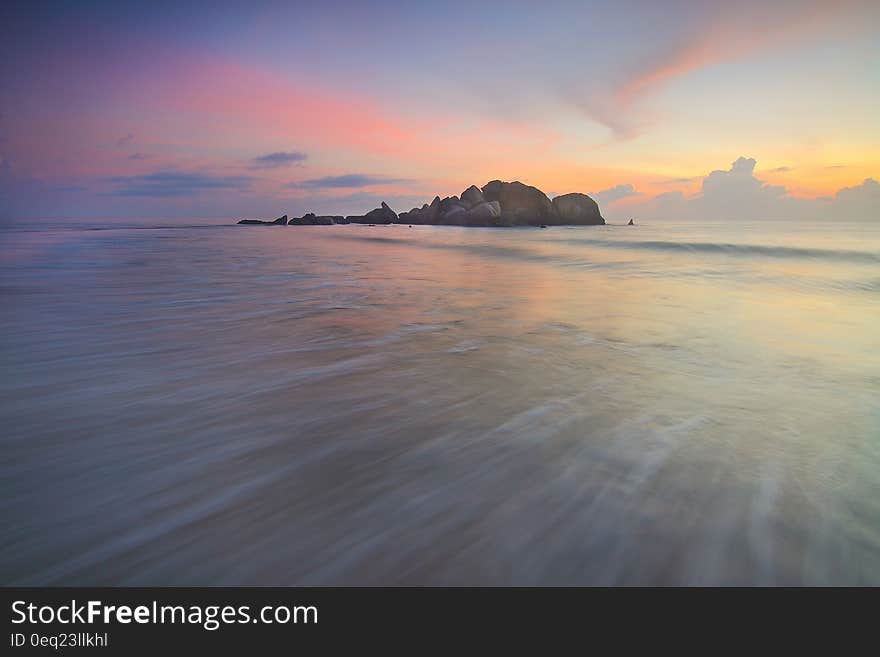 Sunset over island in ocean.