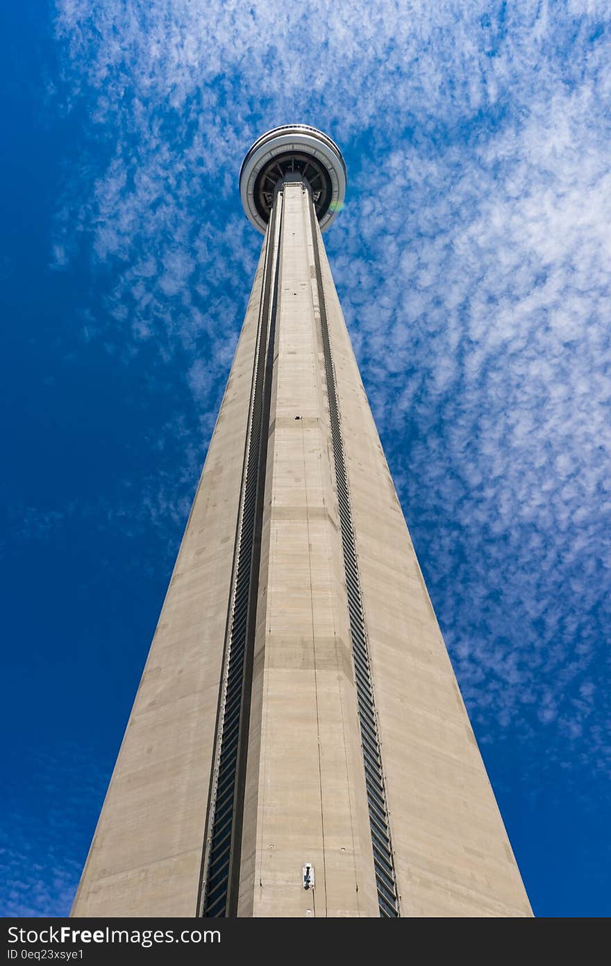 Facade of tall tower against blue skies on sunny day.