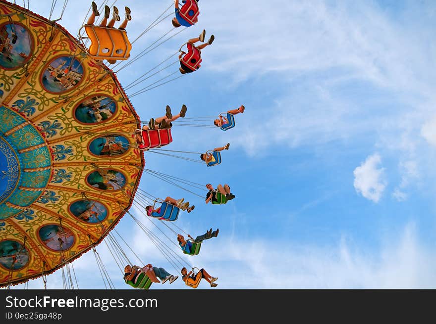 Riders in carnival or amusement park against blue skies. Riders in carnival or amusement park against blue skies.