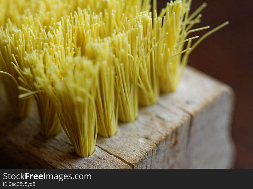 Close up of yellow bristles on wooden broom block. Close up of yellow bristles on wooden broom block.