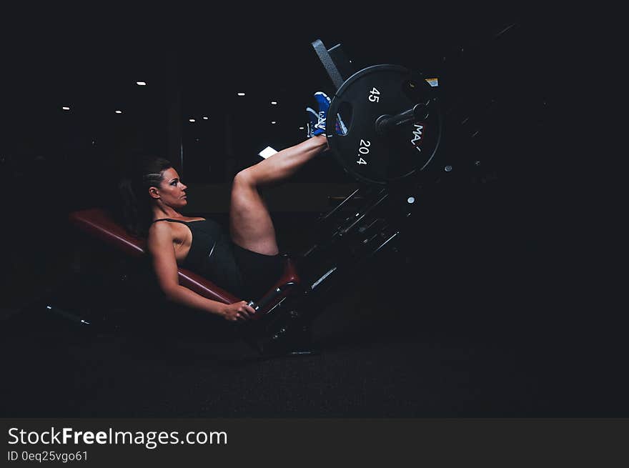 Female athlete in fitness gym performing leg strength training. Female athlete in fitness gym performing leg strength training.