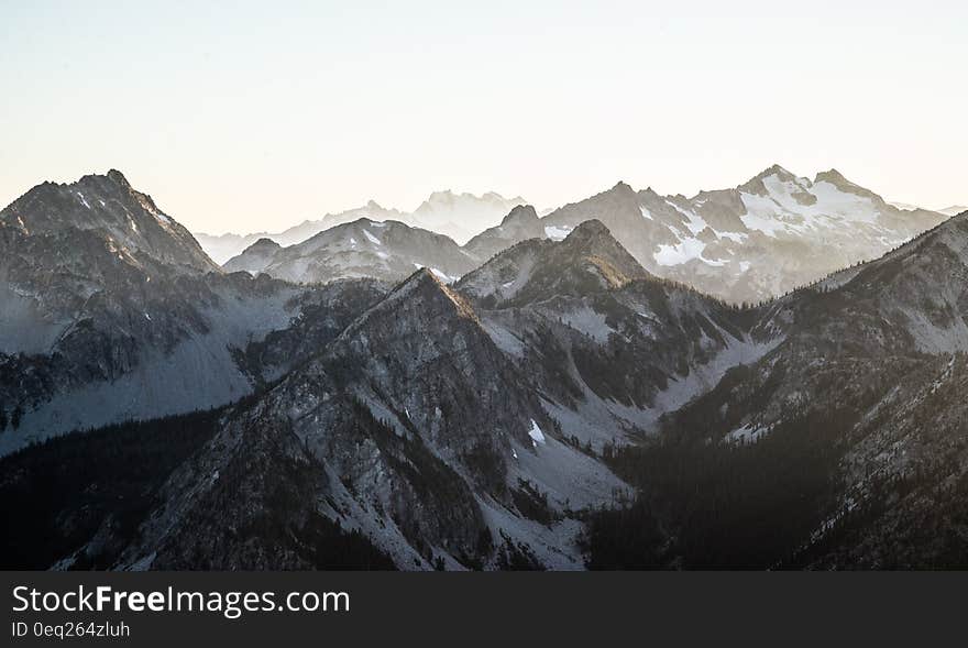 Mountain tops with snow and slopes leading down to narrow valleys, sky threatening more snow. . Mountain tops with snow and slopes leading down to narrow valleys, sky threatening more snow. .