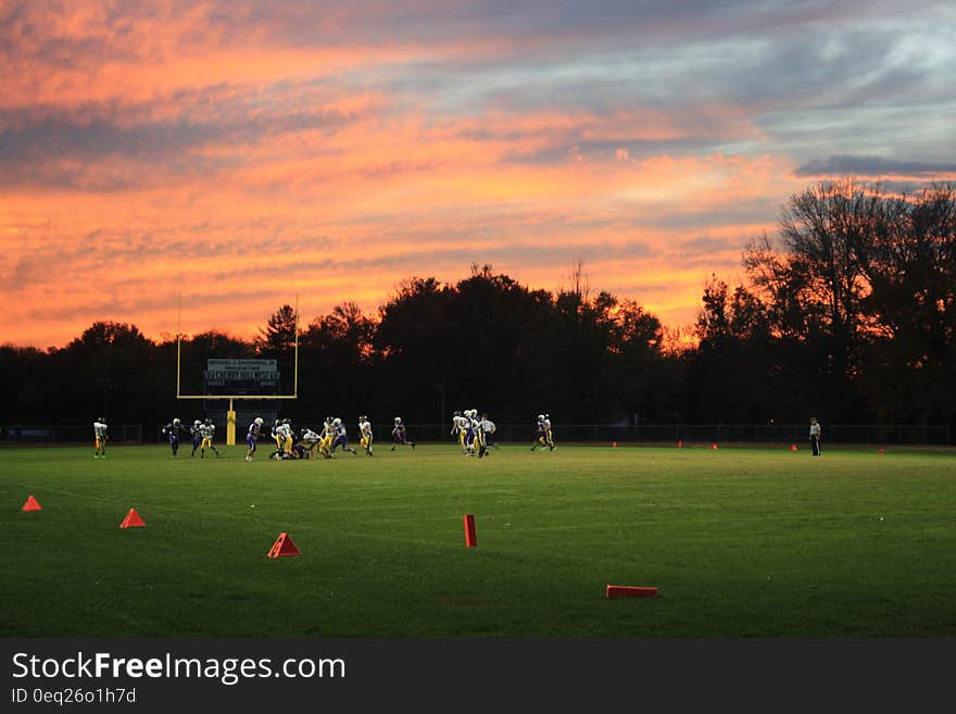 Football game on field with setting sun. Football game on field with setting sun.